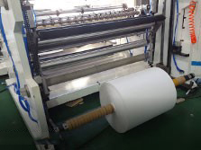 Automatic roll unloading system for removing finished rolls from rewind shaft